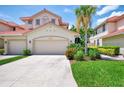 Beautiful two-story villa with a terra cotta roof, multi-car garage, and vibrant landscaping at 4612 Club Dr # D102, Port Charlotte, FL 33953