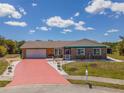 Beautiful home with a two-car garage, stone accents, green trim, and a red driveway at 6417 Klaus Ct, Port Charlotte, FL 33981