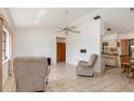 Inviting living room with tile flooring, neutral-toned recliners, and a ceiling fan at 7393 Mamouth St, Englewood, FL 34224