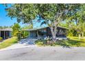 Charming single-story home featuring covered parking, a screened-in lanai and shade tree at 878 Fawnspring Ct, Englewood, FL 34223