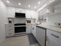 Close-up view of the renovated kitchen featuring stainless steel appliances and white marble countertops at 95 Coquina Ln, Englewood, FL 34223