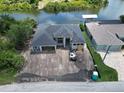 Aerial view of home with water access and a dock, located in a lush, tropical area at 10048 Winnipeg St, Port Charlotte, FL 33981