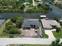 Stunning aerial view of waterfront property with lush landscaping and canal access for boating at 10048 Winnipeg St, Port Charlotte, FL 33981