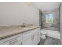 Bathroom with granite vanity, tiled shower, and bath with a tiled wall surrounding the window at 12 Current Ln, Placida, FL 33946