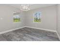 This light-filled bedroom features wood-look flooring, neutral walls, recessed lights and dual windows offering natural views at 12 Current Ln, Placida, FL 33946