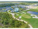 Beautiful aerial view of a community pool and amenity center, tennis courts and a golf course at 12470 Wellen Golf St # 108, Venice, FL 34293