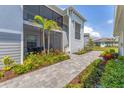 Exterior patio with a screened lanai, patio table and chairs and nicely manicured landscaping at 12470 Wellen Golf St # 108, Venice, FL 34293