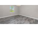 Bedroom with gray wood-look tile flooring, light gray walls, and a bright window at 14 Current Ln, Placida, FL 33946
