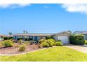 Charming home with well-maintained lawn, manicured landscaping, and inviting entryway at 146 Rotonda Cir, Rotonda West, FL 33947