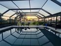 Relaxing pool with a screen enclosure offering a beautiful view of the sunset and golf course at 146 Rotonda Cir, Rotonda West, FL 33947