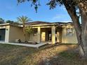 Inviting home entrance framed by palm trees and modern architectural details at 15417 Hanley Ct, Port Charlotte, FL 33953