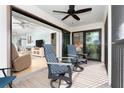 Cozy outdoor seating with view, with two swivel chairs on screened porch with a ceiling fan at 180 N Gulf Blvd # 5, Placida, FL 33946