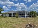 Spacious screened-in pool area surrounded by lush landscaping, perfect for outdoor entertainment and relaxation at 22589 Nyack Ave, Port Charlotte, FL 33952