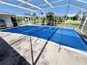 Covered pool area featuring a bright blue pool cover with a view of the surrounding landscape at 22589 Nyack Ave, Port Charlotte, FL 33952