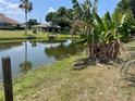 Backyard view of a serene pond, accented by tropical plants and dock at 22589 Nyack Ave, Port Charlotte, FL 33952