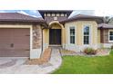 Close-up view of the home's entryway, featuring stone accents and dark double doors at 2758 Morrietta Ln, North Port, FL 34286