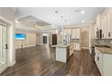 Open-concept living area with modern island kitchen and dark hardwood floors at 2758 Morrietta Ln, North Port, FL 34286
