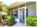 Welcoming front entrance with a decorative security screen door and lush greenery at 305 E Wentworth Cir, Englewood, FL 34223