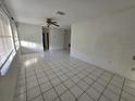Bright living room featuring tile floors, a ceiling fan, and ample natural light from the windows at 3157 Crestwood Dr, Port Charlotte, FL 33952