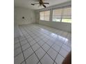 Spacious living room with tile floors, a ceiling fan, and bright windows, offering plenty of natural light at 3157 Crestwood Dr, Port Charlotte, FL 33952