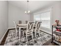 Elegant dining room with a six-chair table and a patterned rug at 3695 Waffle Ter, North Port, FL 34286