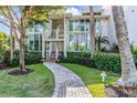 Charming condo building entrance with a landscaped walkway, stairs, and views of the beautiful foliage at 5000 Gasparilla Rd # 8B, Boca Grande, FL 33921