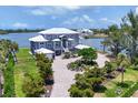 Beautiful waterfront home boasts lush landscaping, circular driveway, and stunning architectural details at 565 Green Dolphin S Dr, Placida, FL 33946
