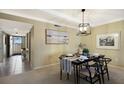 Dining room featuring a modern chandelier and a black table setting for four at 5700 Gulf Shores Dr # B-137, Boca Grande, FL 33921