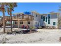 Charming home with an elevated deck, red chairs, views, and neutral paint at 6430 Manasota Key Rd, Englewood, FL 34223