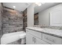 Modern bathroom boasts a granite vanity, decorative tile shower, and contemporary fixtures for comfort at 8270 Cook Ct, Port Charlotte, FL 33981