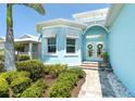 Charming home featuring a beautiful front door with decorative windows and lush landscaping at 8952 Scallop Way, Placida, FL 33946