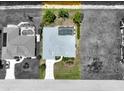 Aerial view of a home with a screened-in pool, lush landscaping, and a driveway leading to an attached garage at 9064 Bantry Bay Blvd, Englewood, FL 34224