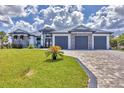 Beautiful single-Gathering home showcasing a 3-car garage, well-manicured lawn, and decorative stone facade at 9532 Miami Cir, Port Charlotte, FL 33981
