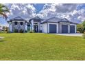 Beautiful single-Gathering home showcasing a 3-car garage, well-manicured lawn, and decorative stone facade at 9532 Miami Cir, Port Charlotte, FL 33981