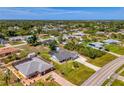 Wide aerial perspective of a residential area with a single-story home, manicured lawn, and a screened-in porch at 9869 Gulfstream Blvd, Englewood, FL 34224