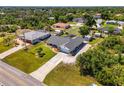 Overhead angle of a single-Gathering home featuring mature landscaping, an expansive lawn, and an adjacent screened in porch at 9869 Gulfstream Blvd, Englewood, FL 34224