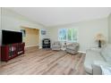 Bright living room featuring neutral paint, lots of natural light, and wood-look flooring at 10116 Melanie Ave, Englewood, FL 34224