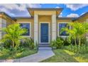 A walkway leads to the home's front entrance framed by columns and complemented by fresh landscaping at 10242 Hallendale Dr, Port Charlotte, FL 33981