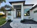 Front entrance of home with columns and a landscaped walkway with decorative rock at 10454 Atenia St, Port Charlotte, FL 33981