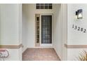 Inviting covered entryway with a decorative front door and brick flooring, leading into the home at 13282 Scrub Jay Ct, Port Charlotte, FL 33953