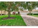 Beautiful single-story home showcasing a brick driveway, two-car garage, and a lush green lawn at 13282 Scrub Jay Ct, Port Charlotte, FL 33953