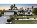 Well-kept home exterior with lush landscaping and palm trees offering curb appeal at 13703 Drysdale Ave, Port Charlotte, FL 33981