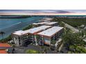A scenic aerial view showing condos with mature landscaping, next to a bay at sunset at 1501 Beach Rd # 310, Englewood, FL 34223