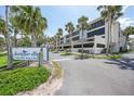 Exterior view of building with a Sandpiper Key sign, mature landscaping and under building parking at 1501 Beach Rd # 310, Englewood, FL 34223