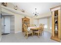 Traditional dining room featuring wood furniture, tile flooring, a modern light fixture, and decorative roosters at 209 Fairway Rd, Rotonda West, FL 33947