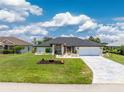 Beautiful single Gathering home with a well-manicured lawn, a long drive way, and lovely landscaping at 209 Fairway Rd, Rotonda West, FL 33947