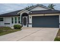 Close-up of home's exterior featuring a large two-car garage and welcoming front entryway at 21 Sportsman Way, Rotonda West, FL 33947