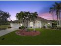 Charming home with lush lawn, mature palms, and arched window by the entryway creates a welcoming curb appeal at 2295 Chilcote Ter, Port Charlotte, FL 33981