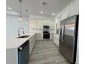 Modern kitchen featuring stainless steel appliances, white cabinets, and quartz countertops at 311 Yule St, Port Charlotte, FL 33953