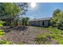 Backyard area surrounded by trees, showing an area ready for landscaping at 3261 Rogue St, North Port, FL 34291